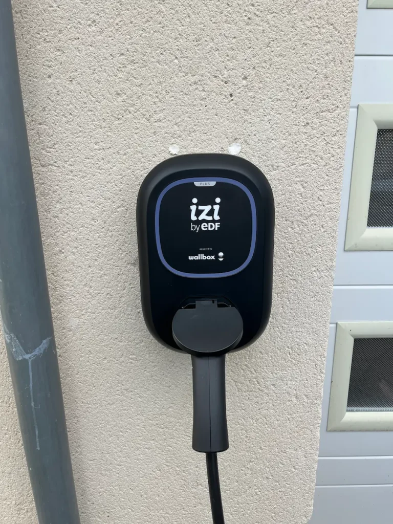 Installation d’une borne de recharge Wallbox IZI by EDF sur une façade extérieure par ALITECH, électricien qualifié IRVE à Angers.